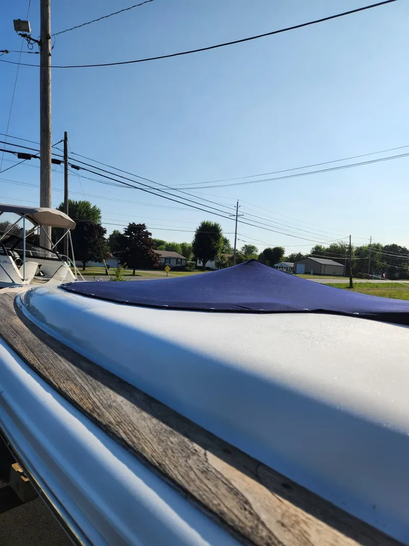 Slide: The Image of 2004 Chris-Craft Launch 28 boat with blue cover, parked outdoors. - 13