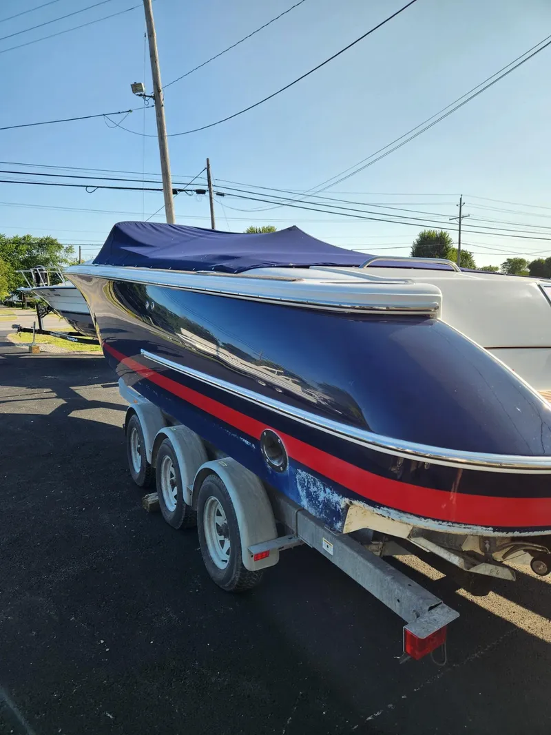 Slide: The Image of 2004 Chris-Craft Launch 28 boat on a trailer, covered with a blue tarp. - 3
