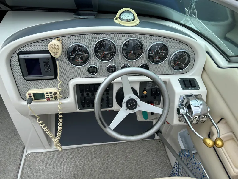 Slide: The Image of 2004 Chris-Craft Launch 28 boat dashboard with steering wheel, gauges, and controls. - 5