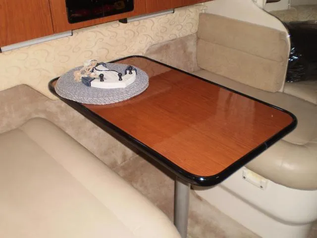 Slide: The Image of 2003 Monterey 302 boat interior with wooden table and beige seating. - 10