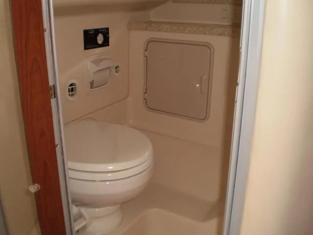 Slide: The Image of 2003 Monterey 302 boat bathroom with toilet and storage compartment. - 15