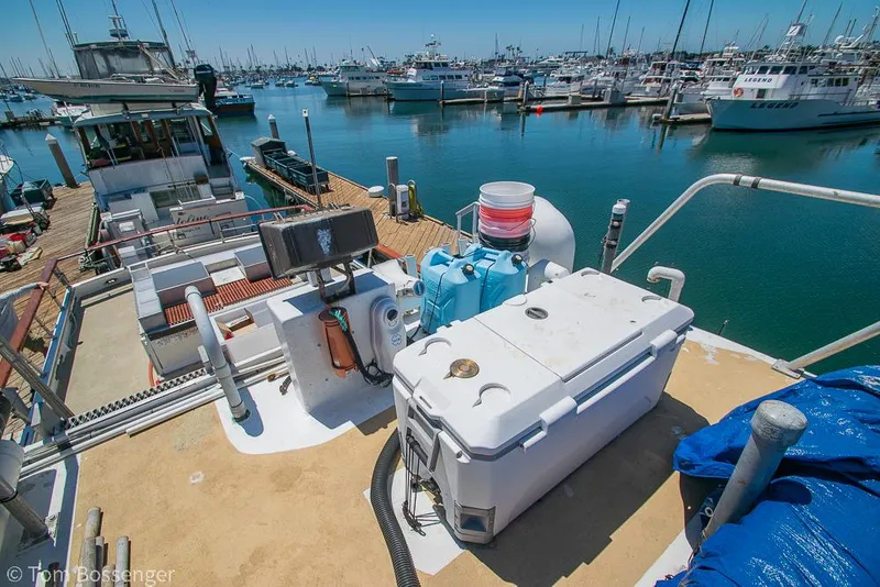 Slide: The Image of 1975 Blanchard Passenger Sportfisher docked at marina, featuring deck equipment and scenic harbor view. - 35