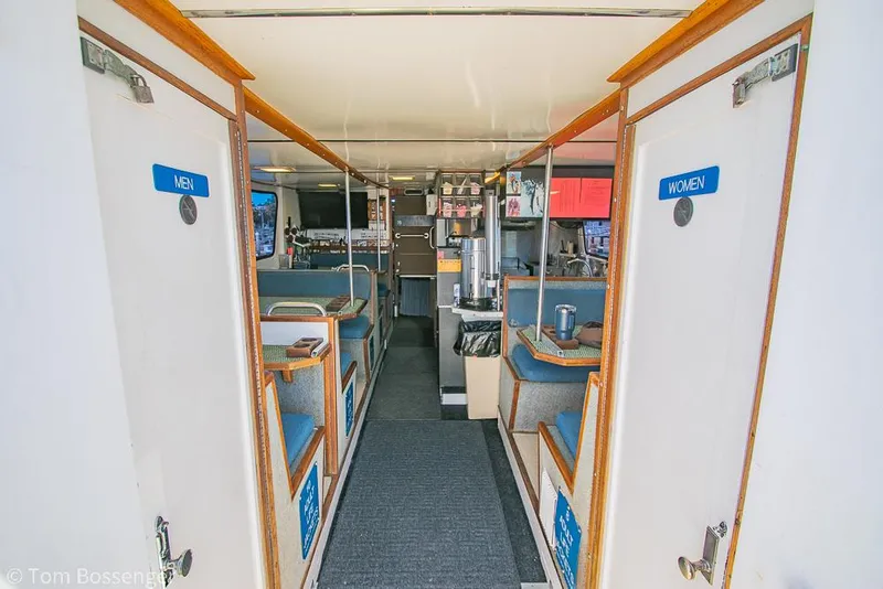 Slide: The Image of Interior of 1975 Blanchard Passenger Sportfisher with seating and restroom doors labeled "Men" and "Women". - 44