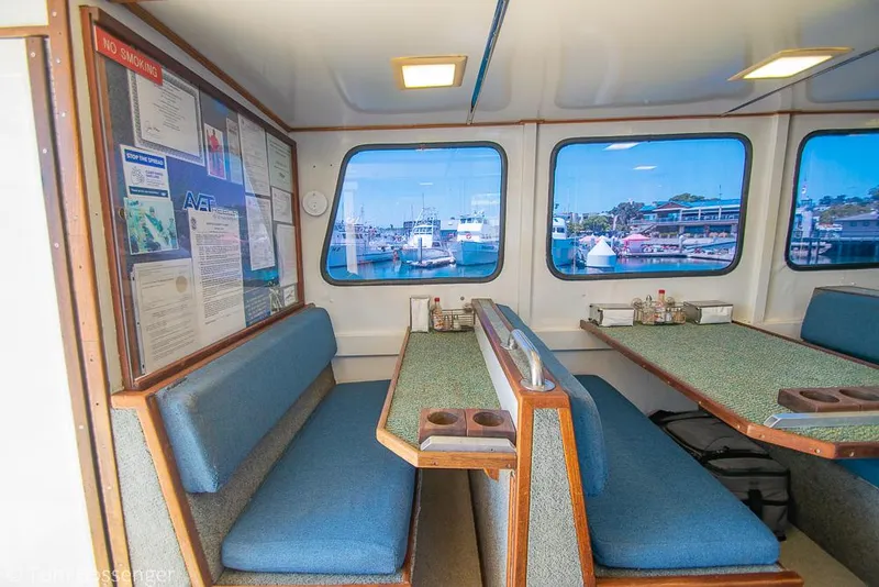 Slide: The Image of Interior of 1975 Blanchard Passenger Sportfisher with blue seating and marina view. - 49