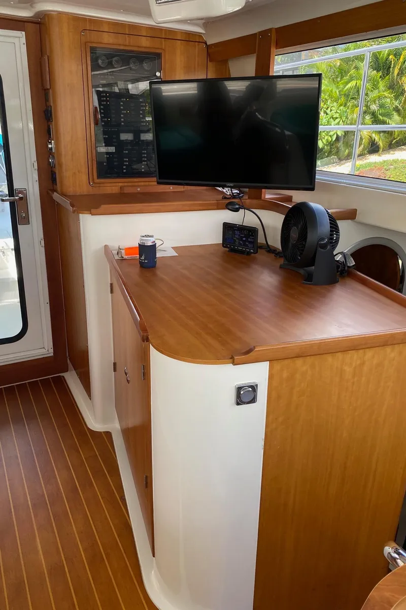 Slide: The Image of 2008 PDQ MV-41 boat interior with wood finish, TV, and window view. - 13