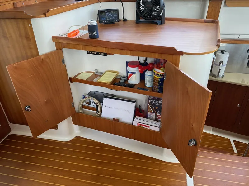 Slide: The Image of Control panel inside 2008 PDQ MV-41 boat, featuring wooden cabinetry and electrical switches. - 14