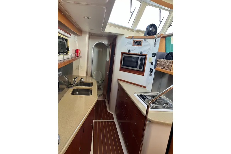 Slide: The Image of 2008 PDQ MV-41 yacht interior with wooden cabinetry and compact kitchen area. - 19