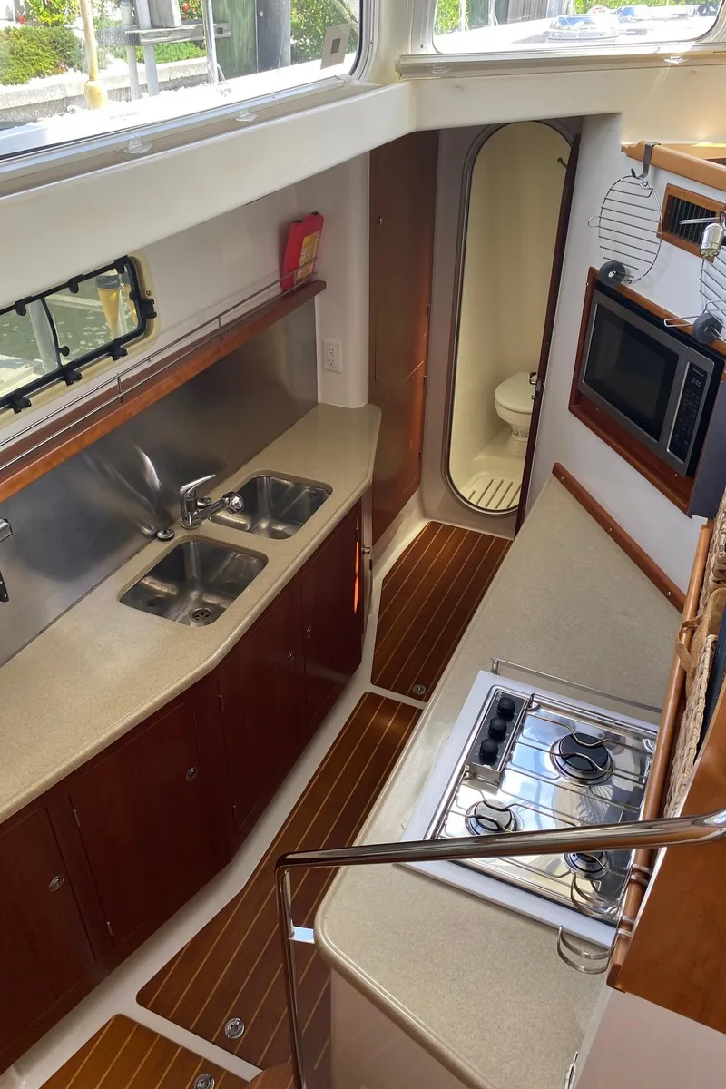 Slide: The Image of Luxurious 2008 PDQ MV-41 yacht kitchen with modern amenities and elegant wood finishes. - 20