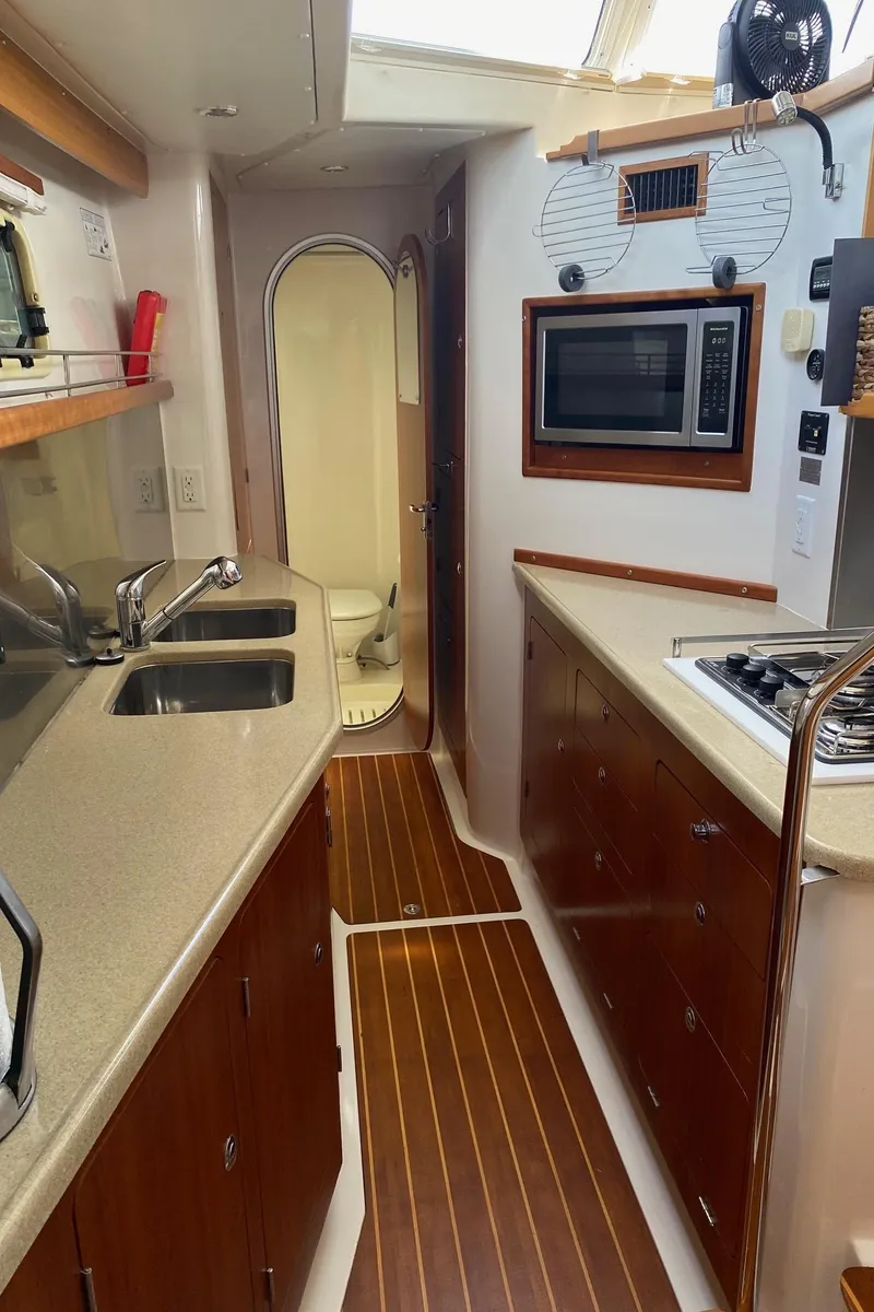 Slide: The Image of 2008 PDQ MV-41 yacht interior with modern kitchen, wood flooring, and sleek countertops. - 21