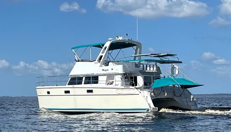 Slide: The Image of 2008 PDQ MV-41 catamaran cruising on open water under a clear blue sky. - 3