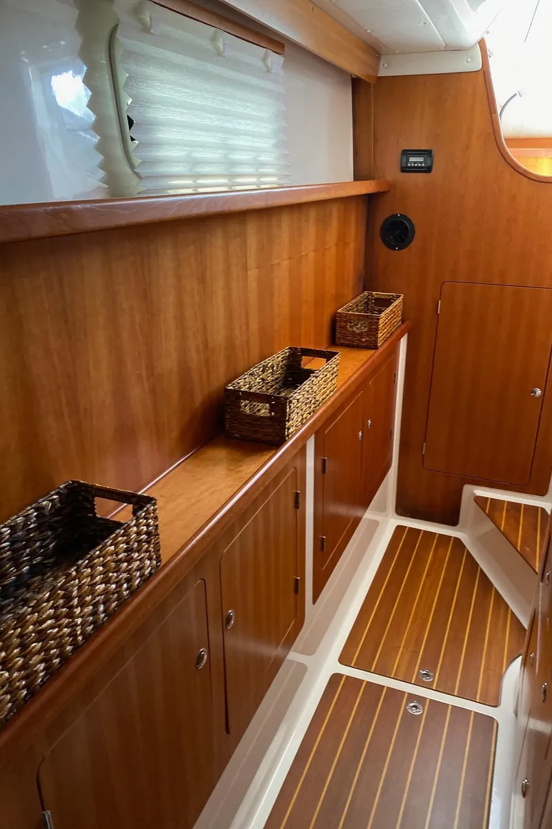 Slide: The Image of Man opening storage compartment on 2008 PDQ MV-41 boat with wooden flooring. - 33