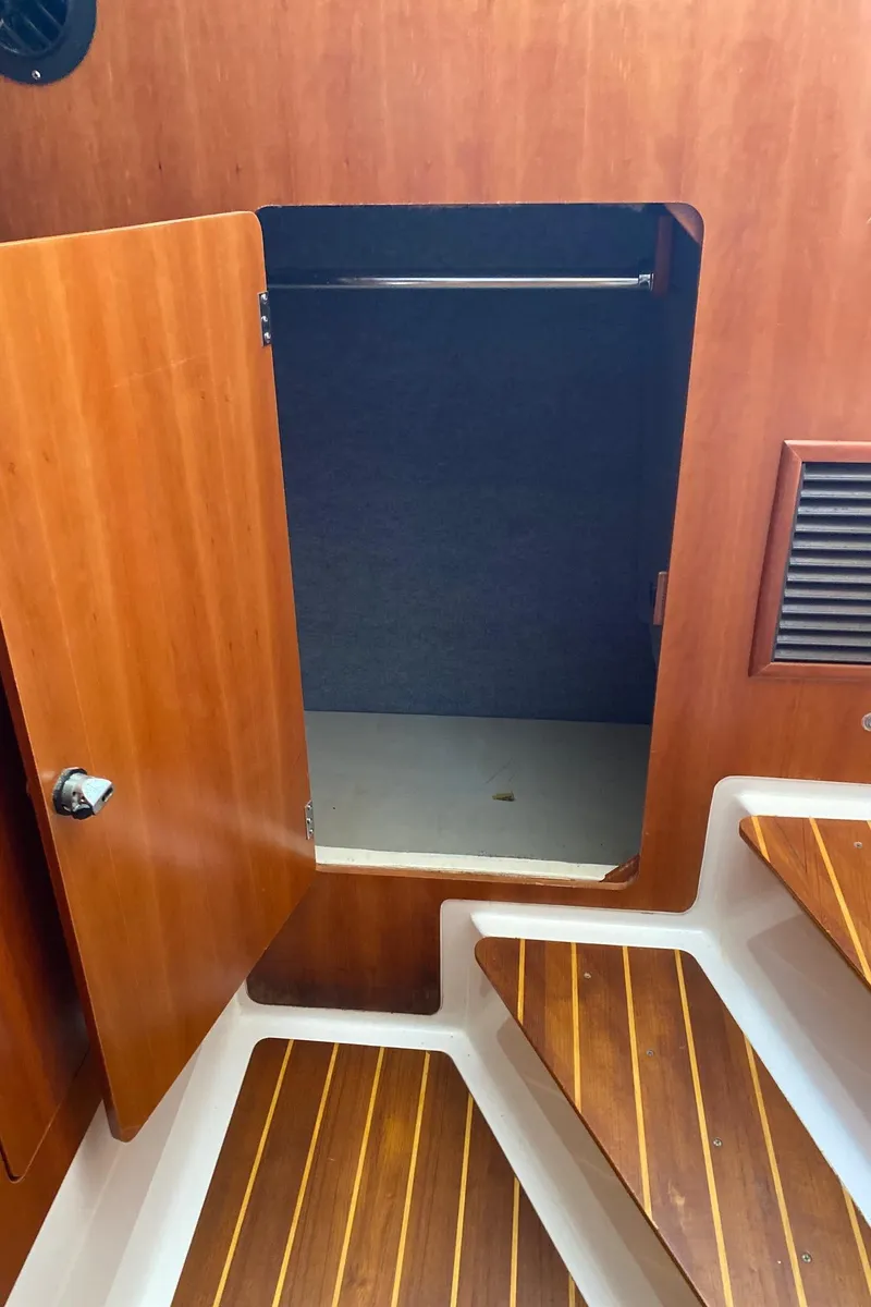 Slide: The Image of Open wooden cabinet on PDQ MV-41 boat, revealing storage space with a container inside. - 40