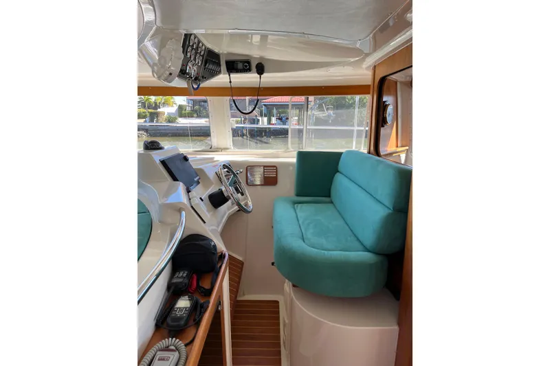 Slide: The Image of Interior of 2008 PDQ MV-41 boat with helm, green seating, and water view. - 8