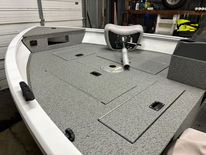 Slide: The Image of 2021 Crestliner 1650 Discovery SC boat interior with gray carpeted deck and swivel seat. - 11