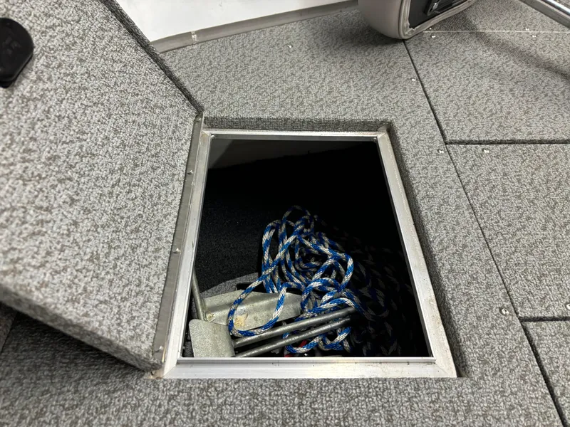 Slide: The Image of Open storage compartment in 2021 Crestliner 1650 Discovery SC boat with rope and anchor. - 3