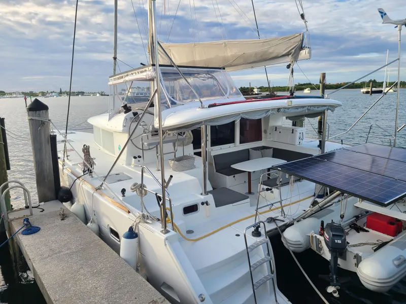 Slide: The Image of 2010 Lagoon 400 owner's version catamaran docked, featuring solar panels and spacious deck. - 11