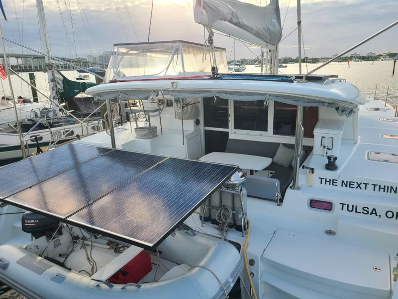 Slide: The Image of 2010 Lagoon 400 owner's version catamaran with solar panels docked at marina. - 12