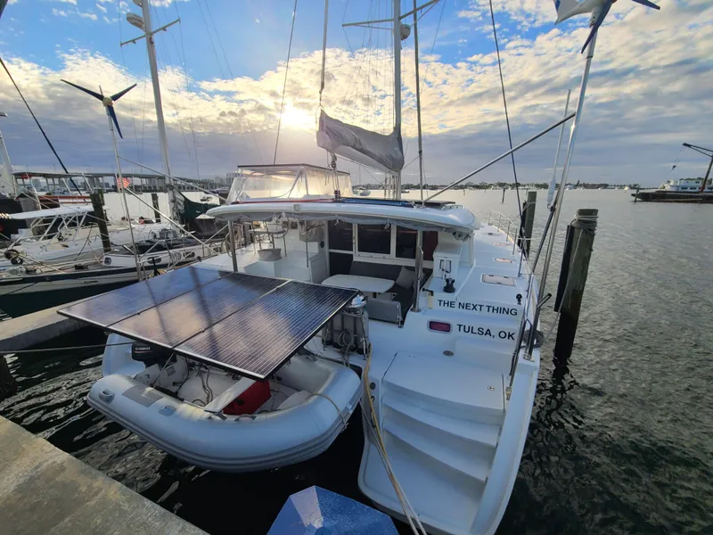 Slide: The Image of 2010 Lagoon 400 owner's version catamaran docked with solar panels and dinghy. - 13