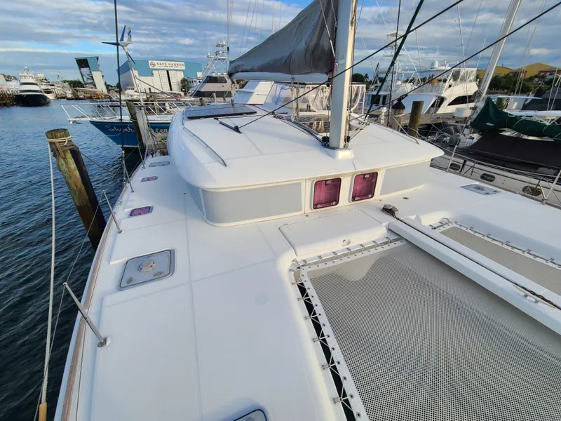 Slide: The Image of 2010 Lagoon 400 owner's version catamaran docked at marina, showcasing deck and sail. - 15