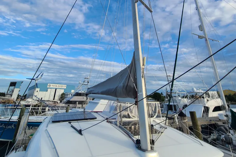Slide: The Image of 2010 Lagoon 400 owner's version catamaran docked at marina under blue sky. - 16