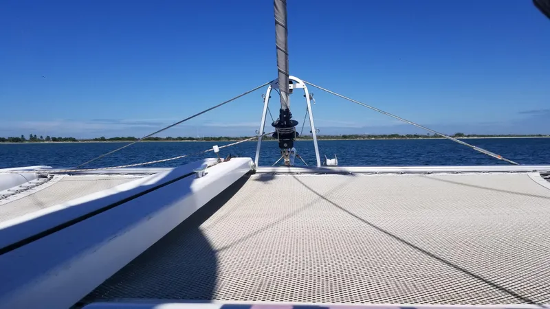 Slide: The Image of Catamaran deck view on water, Lagoon 400 owner's version, 2010 model, under clear blue sky. - 19