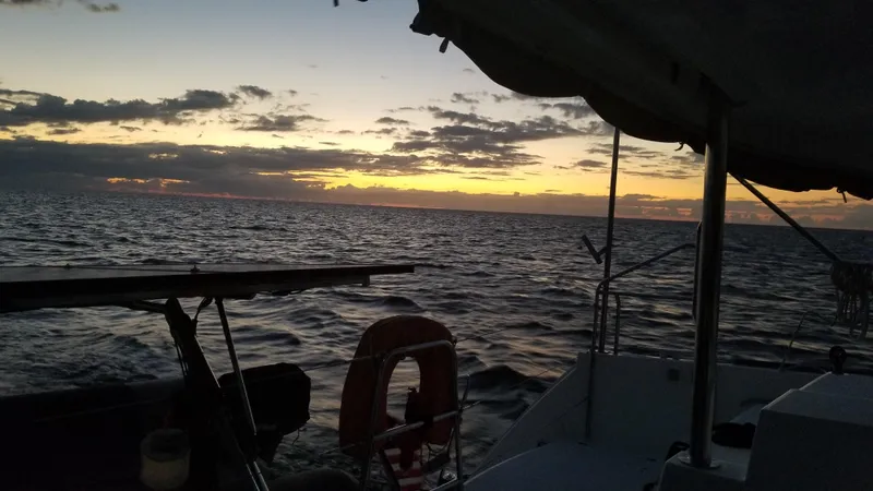 Slide: The Image of Sunset view from a 2010 Lagoon 400 catamaran, silhouetted against the ocean horizon. - 25
