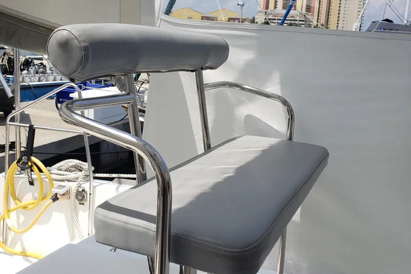 Slide: The Image of Helm seat on 2010 Lagoon 400 owner's version catamaran, featuring stainless steel frame and gray cushions. - 26