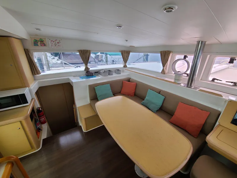 Slide: The Image of Interior of 2010 Lagoon 400 owner's version catamaran with cozy seating and colorful cushions. - 31