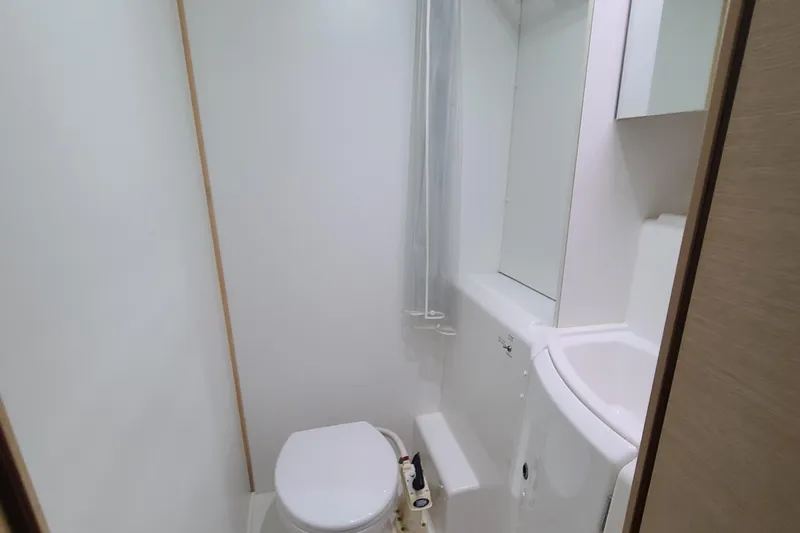 Slide: The Image of Bathroom interior of 2010 Lagoon 400 owner's version catamaran, featuring toilet and sink. - 44