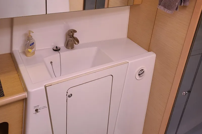 Slide: The Image of 2010 Lagoon 400 owner's version bathroom sink with storage cabinet and soap dispenser. - 46