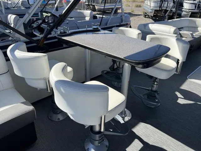 Slide: The Image of 2024 Godfrey Pontoons SW2486MT interior with dining table and swivel chairs. - 8