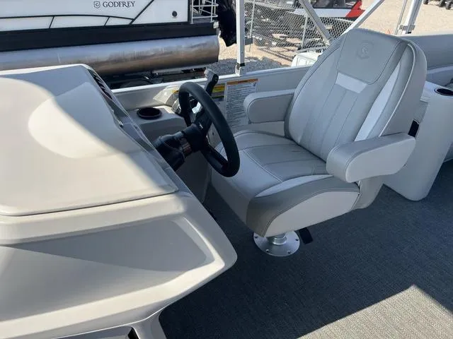 Slide: The Image of Captain's chair and helm of 2025 Godfrey Pontoons EX2286SBX boat. - 6