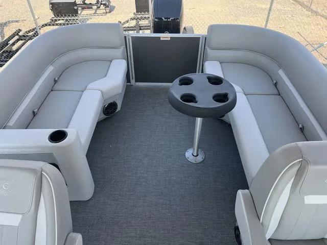 Slide: The Image of 2025 Godfrey Pontoons EX2286SBX interior with gray seating and cup holder table. - 8
