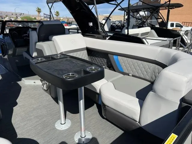 Slide: The Image of 2023 Godfrey Pontoons AquaPatio 256 SBW Twin interior seating and table setup. - 13