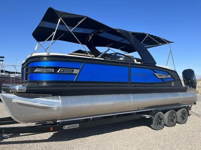 Slide: The Image of 2023 Godfrey Pontoons AquaPatio 256 SBW Twin pontoon boat with blue accents on trailer. - 3