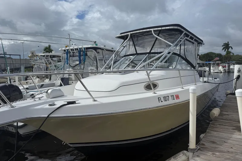 Slide: The Image of 2004 Pro-Line 30 Express Walkaround with twin Mercury outboard engines docked at marina. - 34