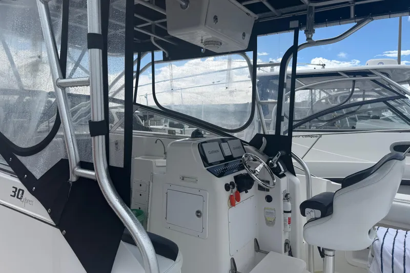 Slide: The Image of 2004 Pro-Line 30 Express Walkaround helm with steering wheel and navigation screens. - 38