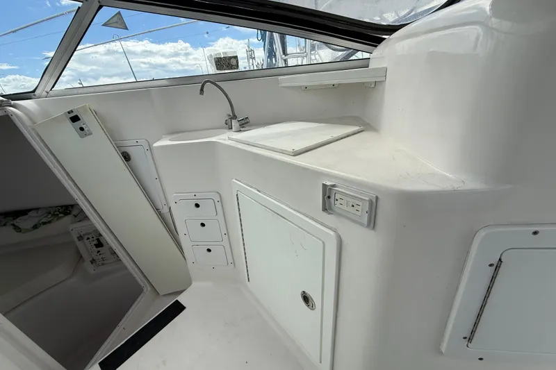 Slide: The Image of 2004 Pro-Line 30 Express Walkaround boat interior with sink and storage compartments. - 40