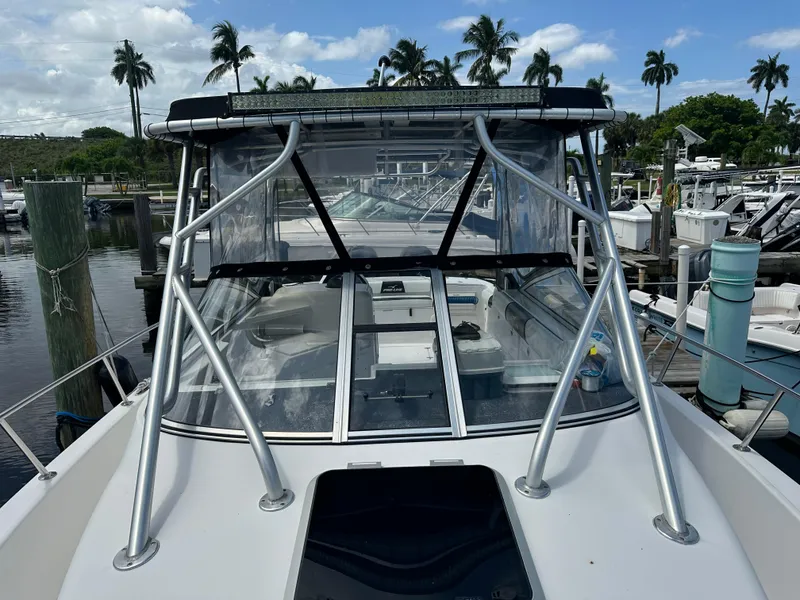 Slide: The Image of 2004 Pro-Line 30 Express Walkaround boat docked at a marina. - 49