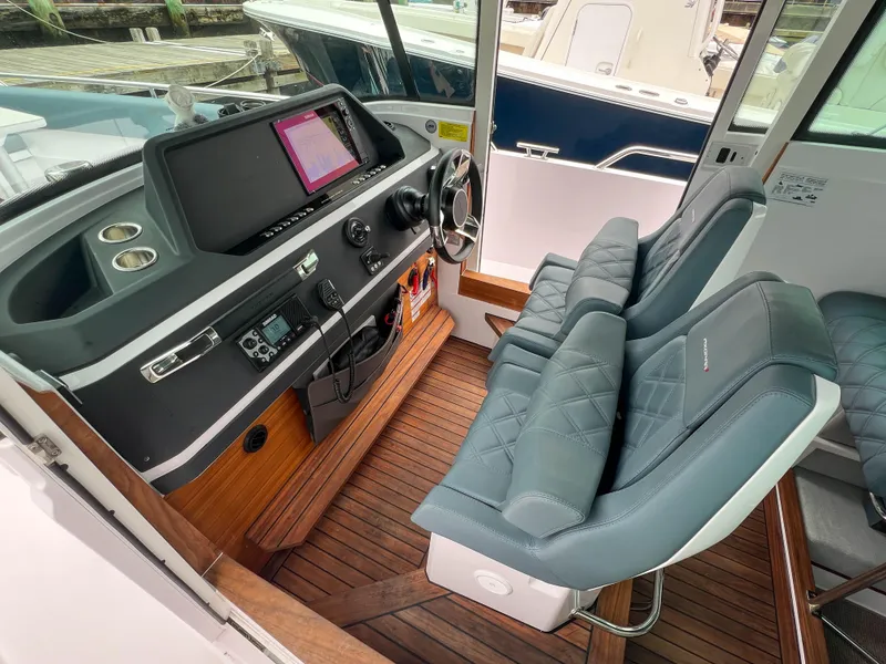 Slide: The Image of 2022 Axopar 28 Cabin Aft Cabin interior with modern helm and comfortable seating. - 13