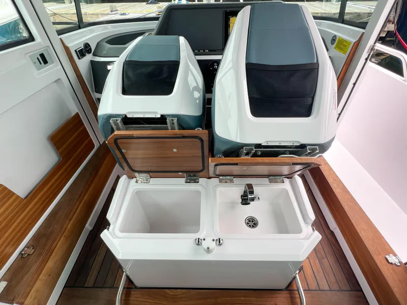 Slide: The Image of 2022 Axopar 28 Cabin Aft Cabin interior with dual seats and sink area. - 24