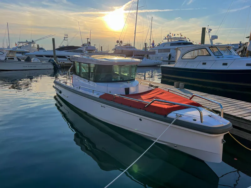 Slide: The Image of 2022 Axopar 28 Cabin Aft Cabin boat docked at sunset in a marina. - 4