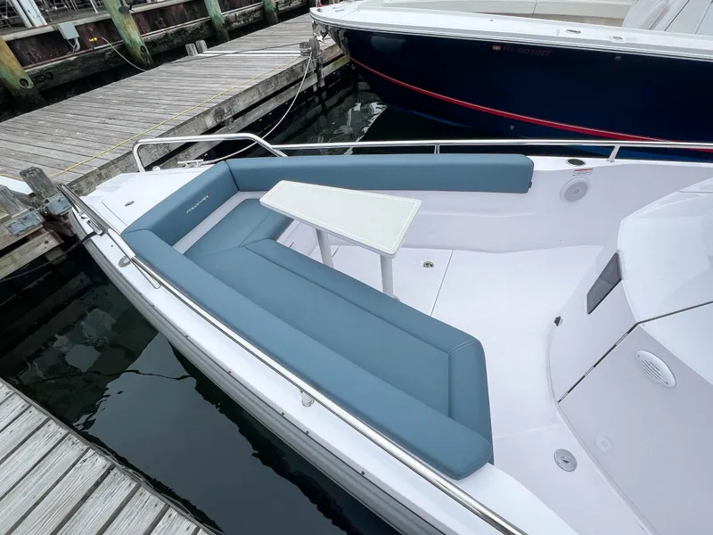 Slide: The Image of 2022 Axopar 28 Cabin Aft Cabin boat with blue seating and white table, docked at marina. - 5