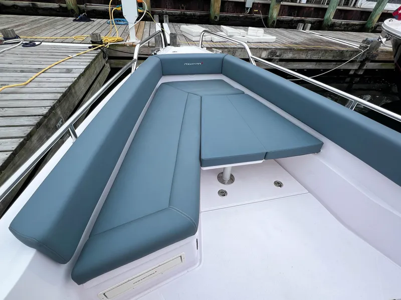 Slide: The Image of 2022 Axopar 28 Cabin Aft Cabin boat with blue seating at dock. - 7