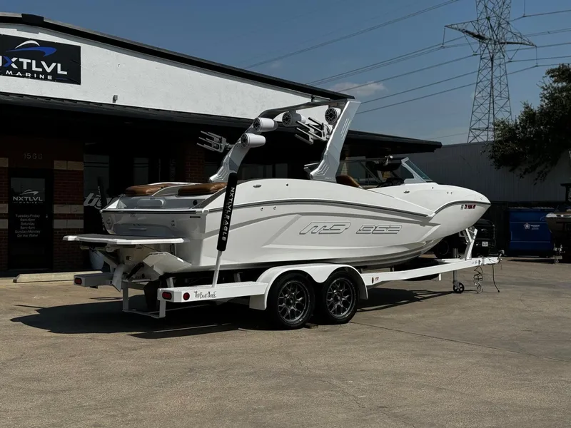 Slide: The Image of 2023 MB SPORTS B52 23 Alpha boat on trailer outside NXT LVL Marine dealership. - 3