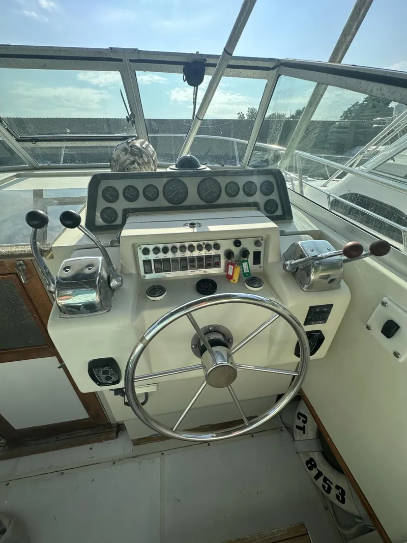 Slide: The Image of 1984 Aquasport 270 Express Fisherman boat helm with steering wheel and controls. - 12