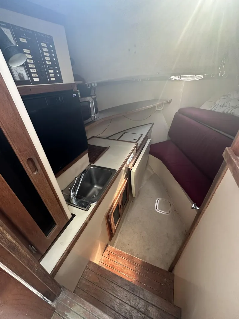 Slide: The Image of 1984 Aquasport 270 Express Fisherman cabin interior with kitchenette and seating area. - 14