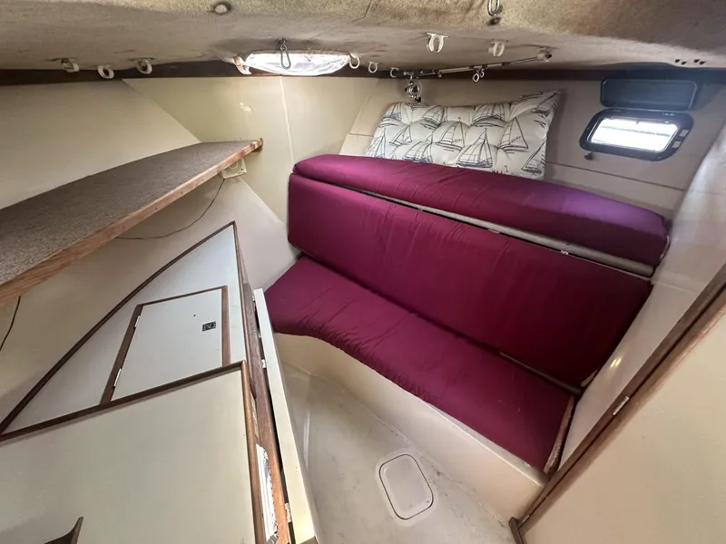 Slide: The Image of 1984 Aquasport 270 Express Fisherman cabin interior with red cushions and storage compartments. - 17