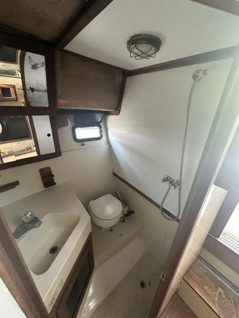 Slide: The Image of 1984 Aquasport 270 Express Fisherman boat bathroom with sink, toilet, and shower. - 21