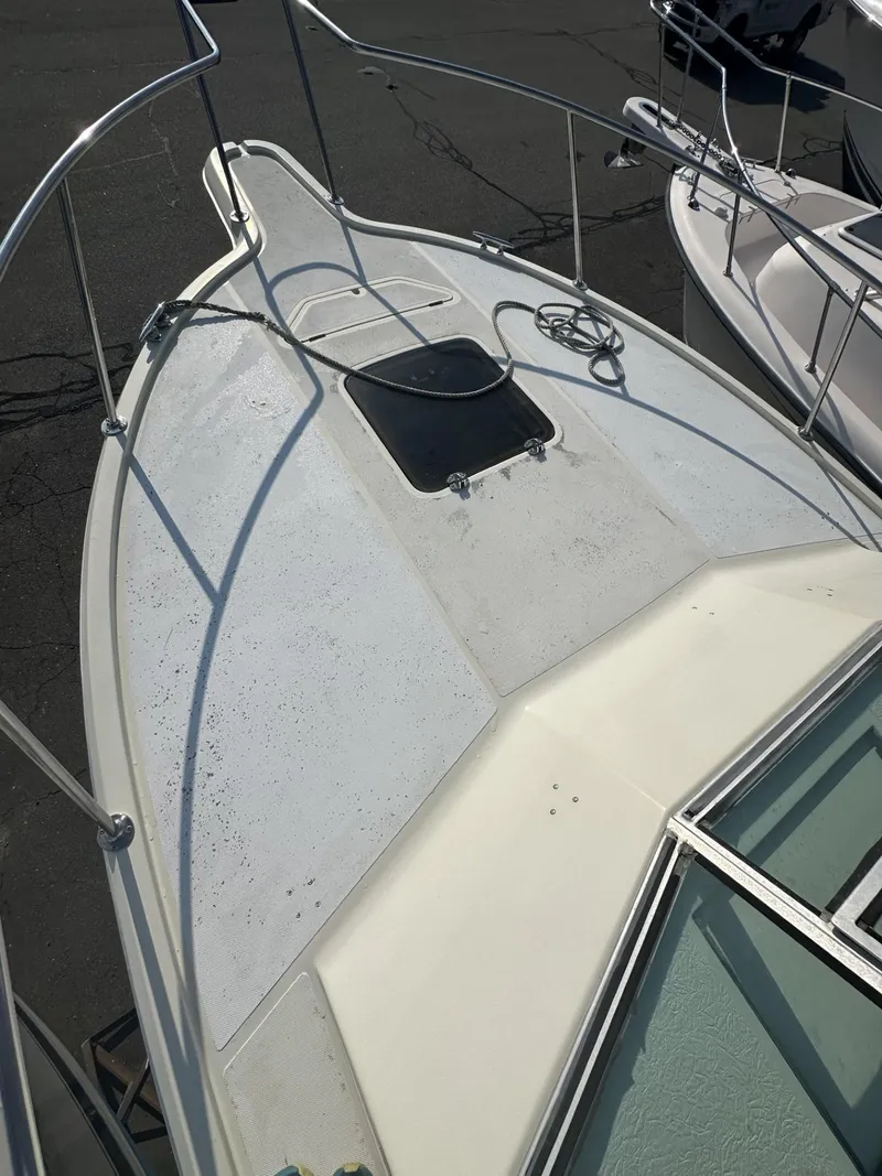 Slide: The Image of 1984 Aquasport 270 Express Fisherman boat deck with hatch and railing. - 28